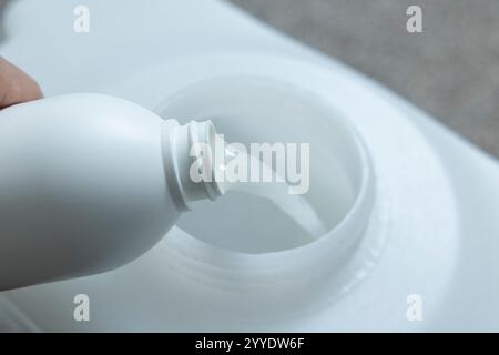 Produit chimique d'encapsulation versé dans le réservoir de pulvérisation d'une machine de nettoyage de tapis CRB à faible humidité à brosse contrarotative Banque D'Images