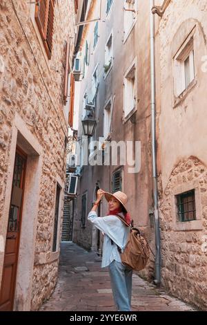 Jeune femme touriste avec sac à dos marchant dans la rue étroite dans la vieille ville européenne Banque D'Images