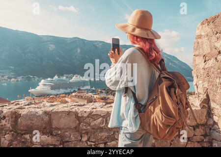Femme touriste prenant photo du bateau de croisière dans la belle baie de Kotor, Monténégro Banque D'Images