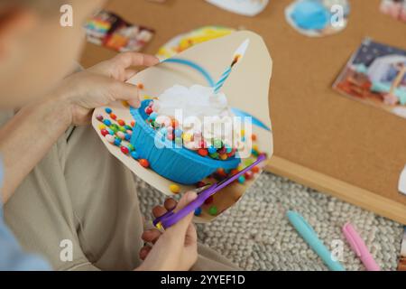 Création d'un tableau de vision. Petit garçon découpant la photo à l'intérieur, gros plan Banque D'Images