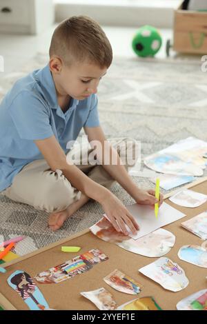 Création d'un tableau de vision. Petit garçon dessinant sur papier à l'intérieur Banque D'Images