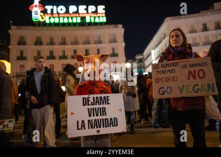 Madrid, Espagne. 21 décembre 2024. Les activistes portant des masques d'animaux tiennent des pancartes lors d'un rassemblement pour les droits des animaux. Des militants pro-animaux de 'animal Save' ont joué à Madrid Puerta del sol avec le slogan : 'Noël : la fête des abattoirs'. Crédit : SOPA images Limited/Alamy Live News Banque D'Images