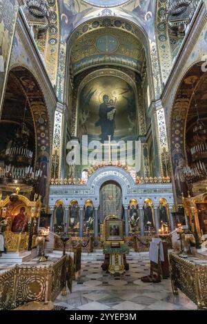 L'intérieur d'une église est éclairé avec des bougies et les murs sont recouverts de peintures. L'atmosphère est paisible et sereine Banque D'Images