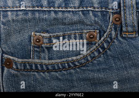Poche en Jean bleue sur le devant, gros plan sur un vieux Jean. Concept de mode, entreprise, shopping, vente. Détail de conception, bouton et coutures, espace de copie. Banque D'Images