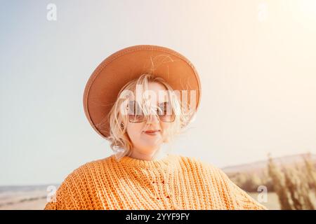 Femme dans un chapeau marron et lunettes de soleil Banque D'Images