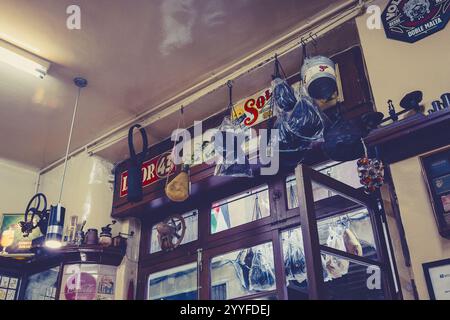 Intérieur vintage rempli de décor éclectique, y compris des panneaux rétro, des outils et des objets suspendus, capturant le charme d'un lieu local rustique Banque D'Images