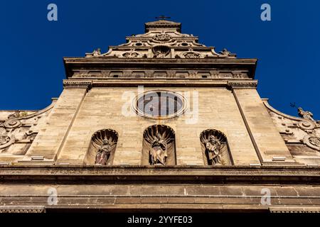 L'église a un grand vitrail. La fenêtre est entourée de statues d'anges. Le bâtiment est vieux et a beaucoup de détails Banque D'Images