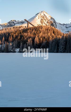 Strbske pleso lac avec Predne Solisko, Mlynicke et Strbske Solisko sommets de montagne au-dessus dans les montagnes des Hautes Tatras en Slovaquie pendant le matin d'hiver Banque D'Images
