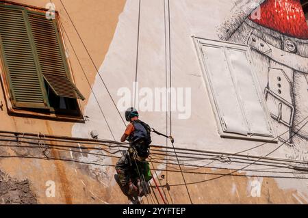 Street art du célèbre artiste Blu dessiné en direct sur la façade de l'ancien hôpital psychiatrique judiciaire (OPG) dans la via Matteo Renato Imbriani à Naples. Banque D'Images