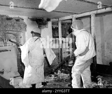 Seconde Guerre mondiale - Riflemen of Co. G, 38e régiment d'infanterie, 2e division d'infanterie, parcourez la porte et la fenêtre de la grange abandonnée avant de partir près de Wirtzfeld, Belgique. 31 janvier 1945. Photo du corps du signal Banque D'Images