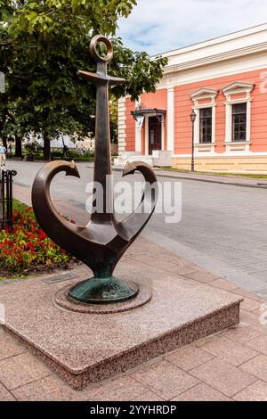 Une grande statue d'ancre se trouve sur un piédestal de pierre devant un bâtiment. La statue est entourée de fleurs, ajoutant une touche de couleur et de vie à la SC Banque D'Images