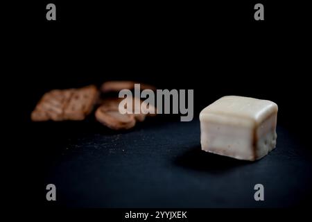 Snack de Noël fait de chocolat blanc et spéculoos isolé sur un fond noir avec espace texte Banque D'Images