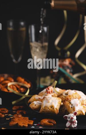 Réveillon du nouvel an, viennoiseries et verres à champagne sur une table, verser du champagne Banque D'Images