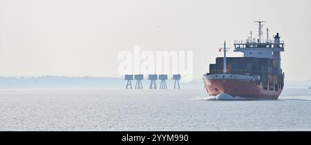 Tamise près de Tilbury porte-conteneurs faisant place à travers la tamise avec Maunsel (tours de sable rouge) à distance Banque D'Images