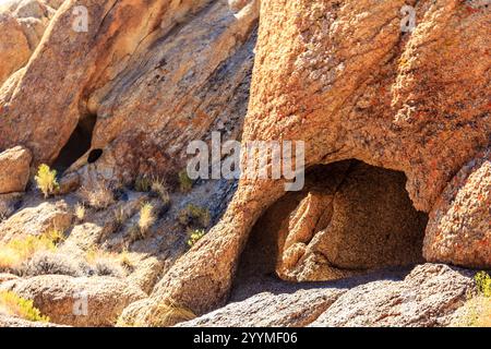 Une colline rocheuse avec un grand trou au milieu. Le trou est entouré de rochers et il est une grotte naturelle. Scène est une de solitude et de mystère, comme t Banque D'Images