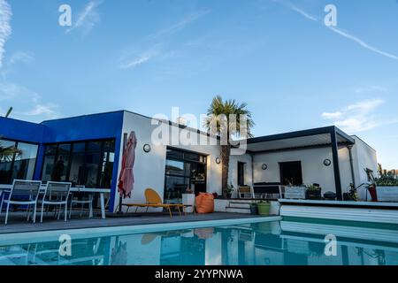 photo réaliste design moderne pergola bioclimatique avec lattes en aluminium qui se trouve près d'une maison moderne avec piscine , avec salle à manger , riche en Banque D'Images