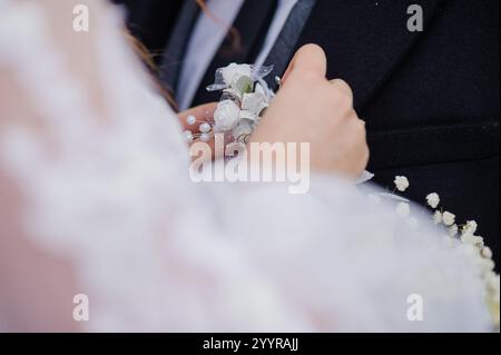 Moment romantique : mariée tenant corsage le jour du mariage. Banque D'Images