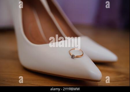 Chaussures de mariage élégantes avec un anneau de fiançailles étincelant. Banque D'Images