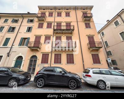 VÉRONE, ITALIE - 27 OCTOBRE 2024 : bâtiment avec fenêtres fermées à Vicolo di San Zeno in Oratorio (San Zenetto) église à Vérone, voitures garées dans la rue Banque D'Images