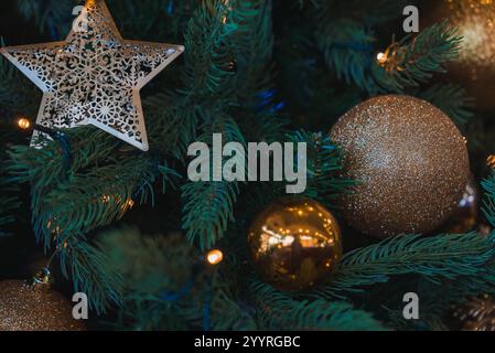 Un sapin de Noël orné d'étoiles métalliques et de boules dorées illuminées par des lumières chaudes, capturant l'ambiance festive de Londres. Banque D'Images