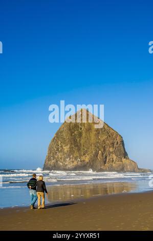 Les amateurs de plage sur Cannon Beach et Haystack Rock, Cannon Beach, Oregon. Banque D'Images