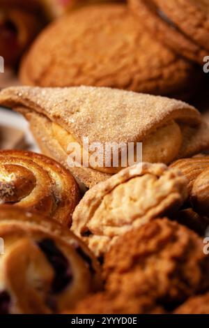 Assortiment de produits de boulangerie exposés sur une table en bois, présentant diverses textures et formes Banque D'Images