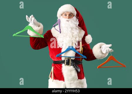 Père Noël avec différents cintres sur fond vert Banque D'Images