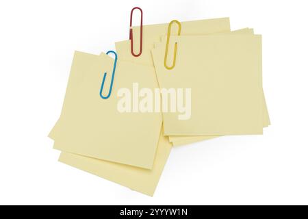 Table de bureau avec stylo, papiers-notes et trombones vue de dessus. Post-it vierge avec trombone jaune isolé sur blanc Banque D'Images