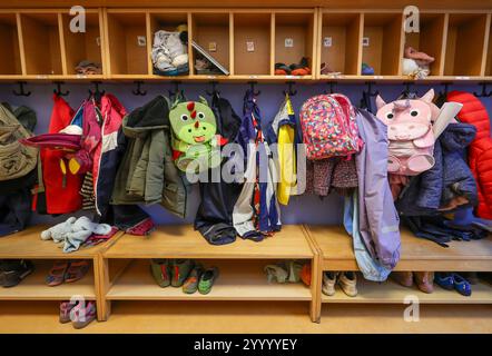 Allemagne - image symbolique KITA. Manteaux, vestes et sacs à dos licorne d'enfants accrochés à un vestiaire dans un jardin d'enfants. Banque D'Images