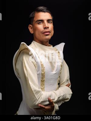 Un homme confiant, probablement un mannequin ou un acteur, pose dans un studio sur fond noir. Banque D'Images