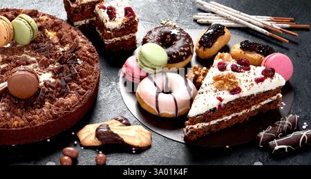 Assortiment de confiseries, différents types de desserts sur table sombre. Banque D'Images