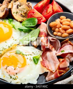 Petit déjeuner anglais complet avec oeuf au plat, saucisse, bacon et pain grillé Banque D'Images