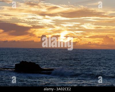 Les vagues s'écrasent sur une formation rocheuse au coucher du soleil à Essaouria, au Maroc. Février/mars 2025 Banque D'Images