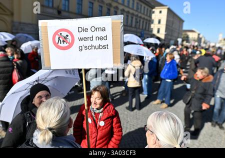 Munich, Allemagne. 02 mars 2025. Les participants à la manifestation contre la droite sous le slogan "maintenant plus que jamais - nous resterons forts" tiennent une pancarte "Die Oma werd ned g'schubst" sur Odeonsplatz. Crédit : Uwe Lein/dpa/Alamy Live News Banque D'Images