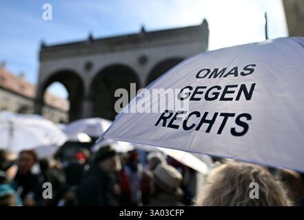 Munich, Allemagne. 02 mars 2025. Les participants à la manifestation contre la droite sous la devise "maintenant plus que jamais - nous resterons forts" se tiennent devant la Feldherrenhalle sur Odeonsplatz avec un parapluie "Grannies contre la droite". Crédit : Uwe Lein/dpa/Alamy Live News Banque D'Images