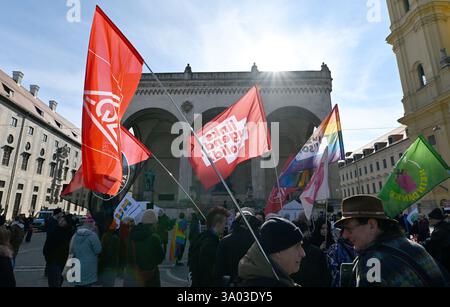 Munich, Allemagne. 02 mars 2025. Les participants à la manifestation contre la droite sous le slogan "maintenant plus que jamais - nous resterons forts" se tiennent debout avec leurs drapeaux devant la Feldherrenhalle sur Odeonsplatz. Crédit : Uwe Lein/dpa/Alamy Live News Banque D'Images