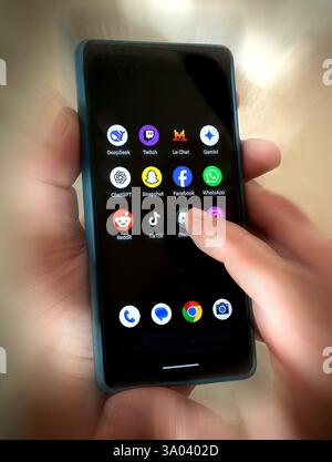 Une personne interagit avec un smartphone affichant plusieurs applications multimédias. Banque D'Images