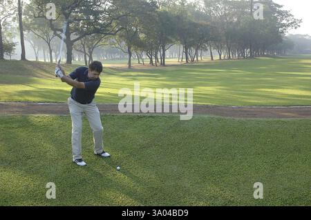Homme jouant au golf en position de frapper la balle, balle de golf et club, Golf Club, Chembur, Bombay Bombay, Maharashtra, Inde, Asie Banque D'Images