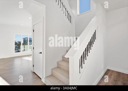 Escalier menant à un deuxième étage avec vue sur l'extérieur. L'escalier est en bois et a une balustrade noire Banque D'Images