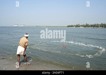 Pêcheur jetant un filet de pêche en mer, Cochin Kochi, Kerala, Inde 2010 Banque D'Images