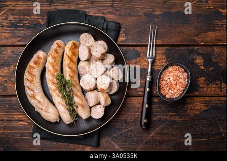 Saucisses grillées avec de la viande de forçage mincemat et des herbes dans l'assiette. fond en bois. vue de dessus. Banque D'Images