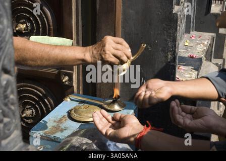 Prêtre versant charnaamrita sur les mains des dévots, Trivandram, Kerala, Inde, Asie Banque D'Images