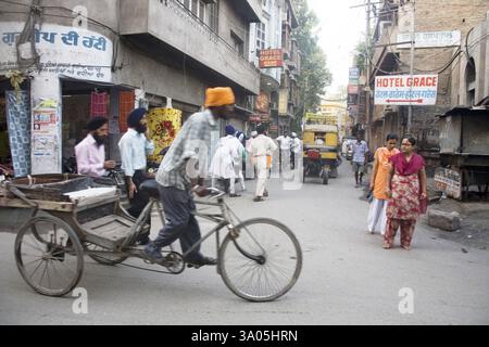 Rickshaw cycliste de scène de rue portant l'homme sikh dans une ruelle près du temple d'or Swarn Mandir, Amritsar, Punjab, Inde, Asie Banque D'Images