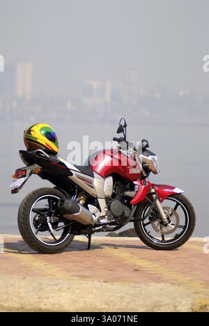 Moto yamaha FZ 150cc couleur rouge vélo sport avec casque coloré, Inde, Asie Banque D'Images