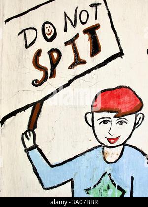 Peinture murale peinte à la main à l'extérieur d'une école de Kolkata décourageant de cracher dans les espaces publics, mettant en vedette une figure caricaturale tenant une pancarte indiquant « ne crachez pas ». Banque D'Images