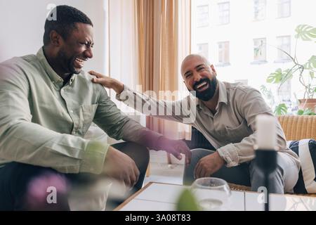Portrait d'un professionnel d'affaires heureux appréciant le temps de pause avec un collègue masculin au bureau Banque D'Images
