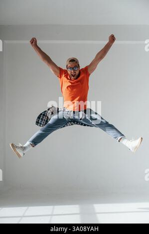 Happy Guy saute, crie et célèbre le succès. Bel homme est dans le studio sur fond blanc. Banque D'Images