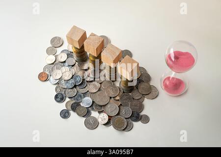 Quatre blocs de bois sur le dessus des pièces de monnaie. À côté de la minuterie de sable. Banque D'Images