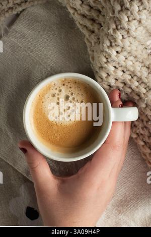 Femme tenant une tasse mousseuse d'espresso Banque D'Images