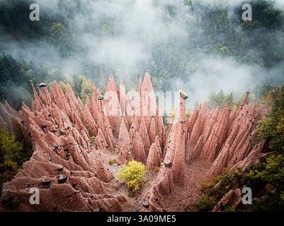 Pyramides de Terre formations rocheuses émergeant du brouillard Banque D'Images
